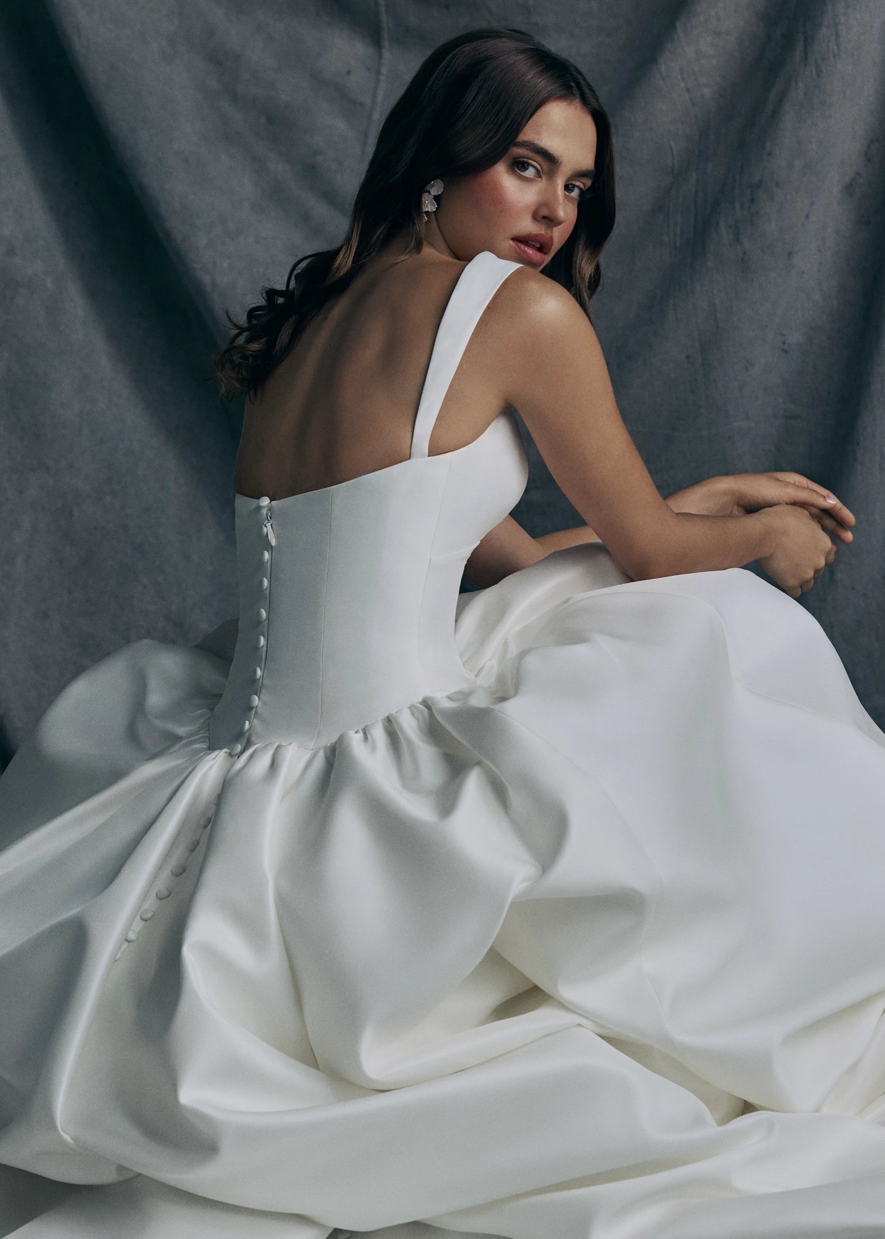 Back view of the Verite gown by Anne Barge is a sculpted sweetheart ballgown in Kalika with contour straps, featuring a ziggurat dropped waist and buttons to the hem. 