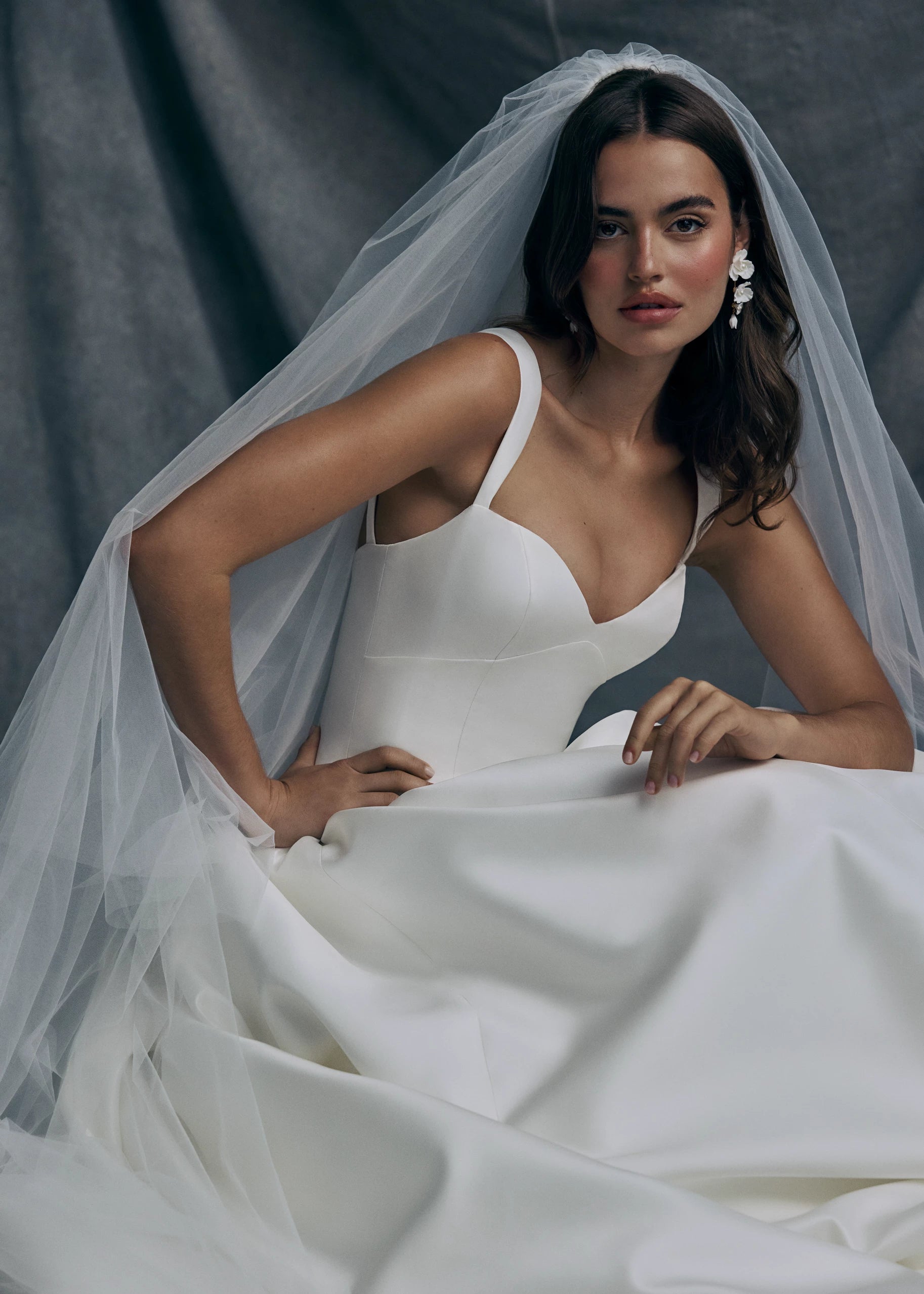 The Verite gown by Anne Barge is a sculpted sweetheart ballgown in Kalika with contour straps, featuring a ziggurat dropped waist and buttons to the hem. 