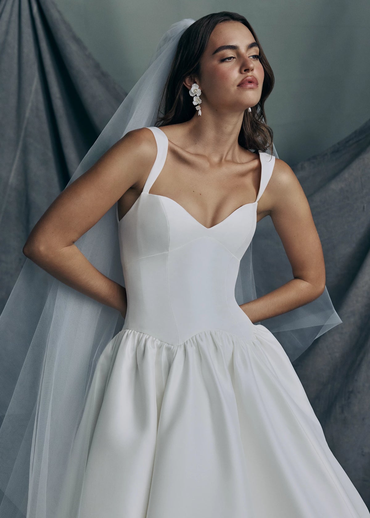 The Verite gown by Anne Barge is a sculpted sweetheart ballgown in Kalika with contour straps, featuring a ziggurat dropped waist and buttons to the hem. 